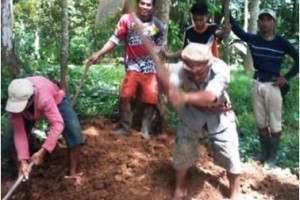 Warga setempat sedang membersihkan longosran yang menutupi jalan.
